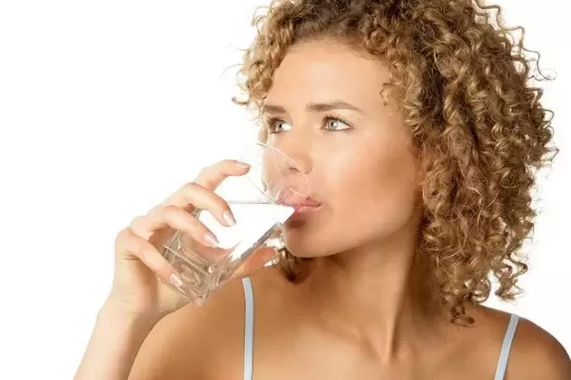 A menina segue uma dieta para preguiçosos, bebendo um copo d'água antes de comer